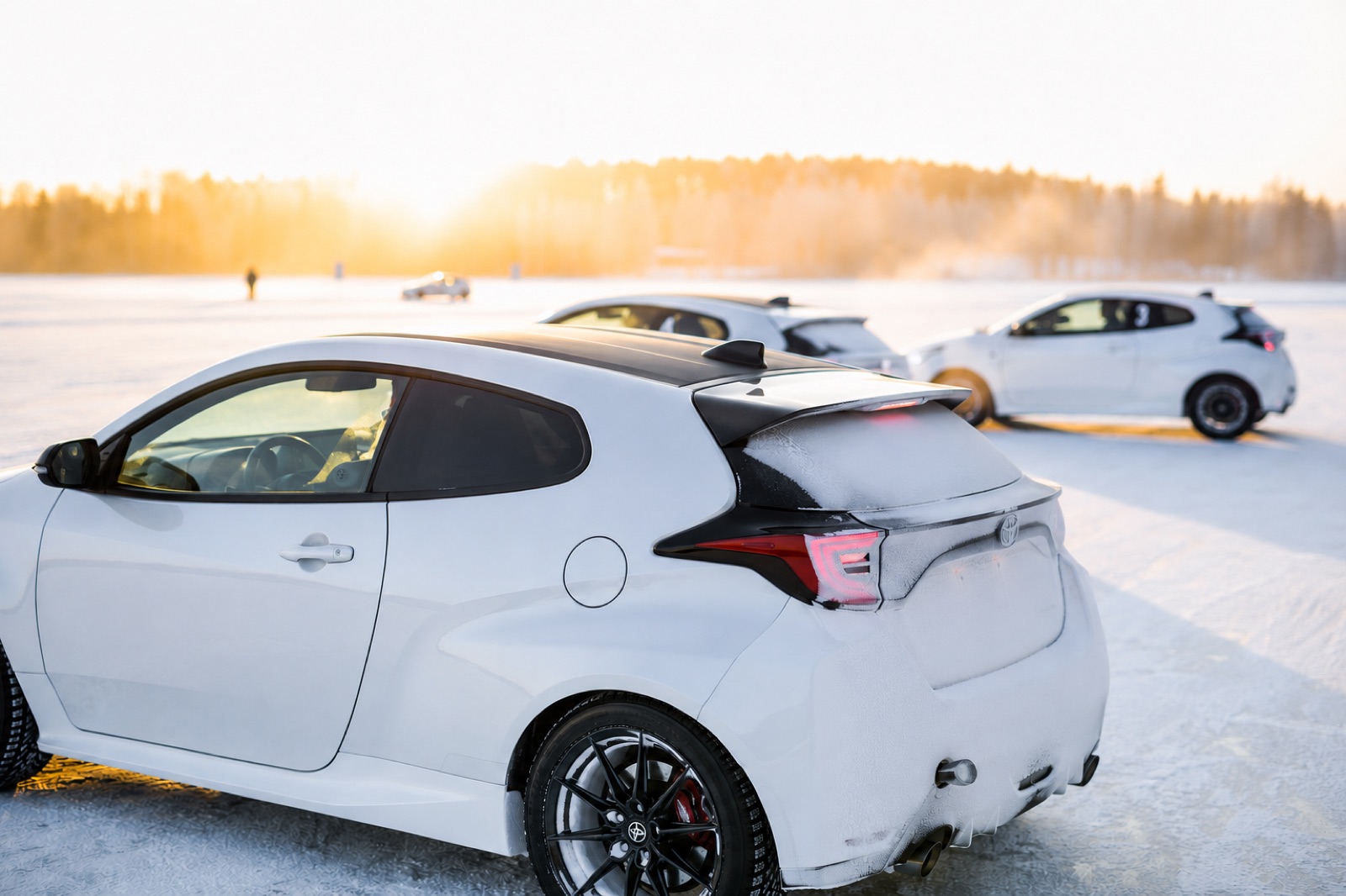 GR Yaris rally cars on the ice at sunset