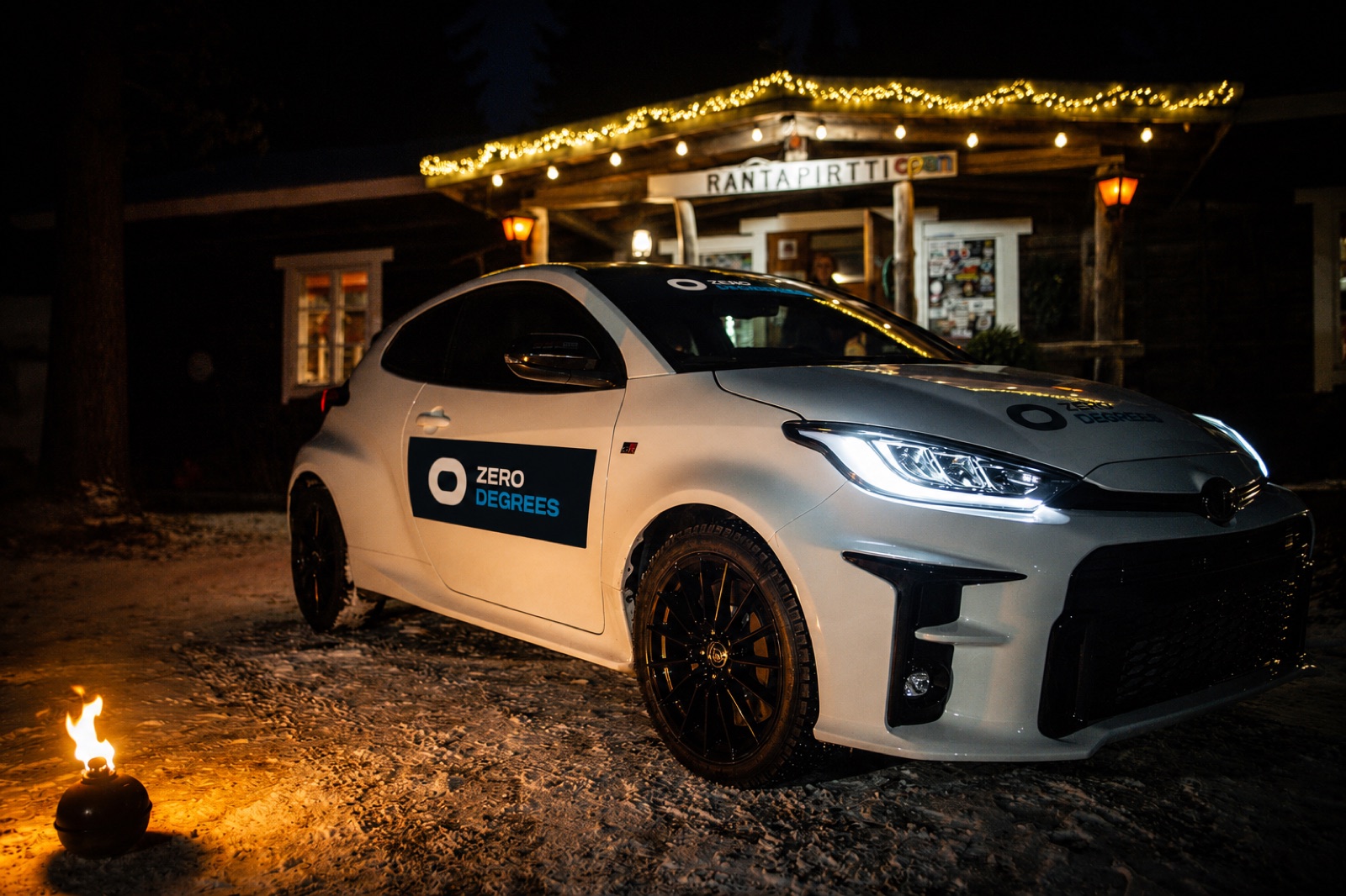 The lodge at night, firelight and a GR Yaris